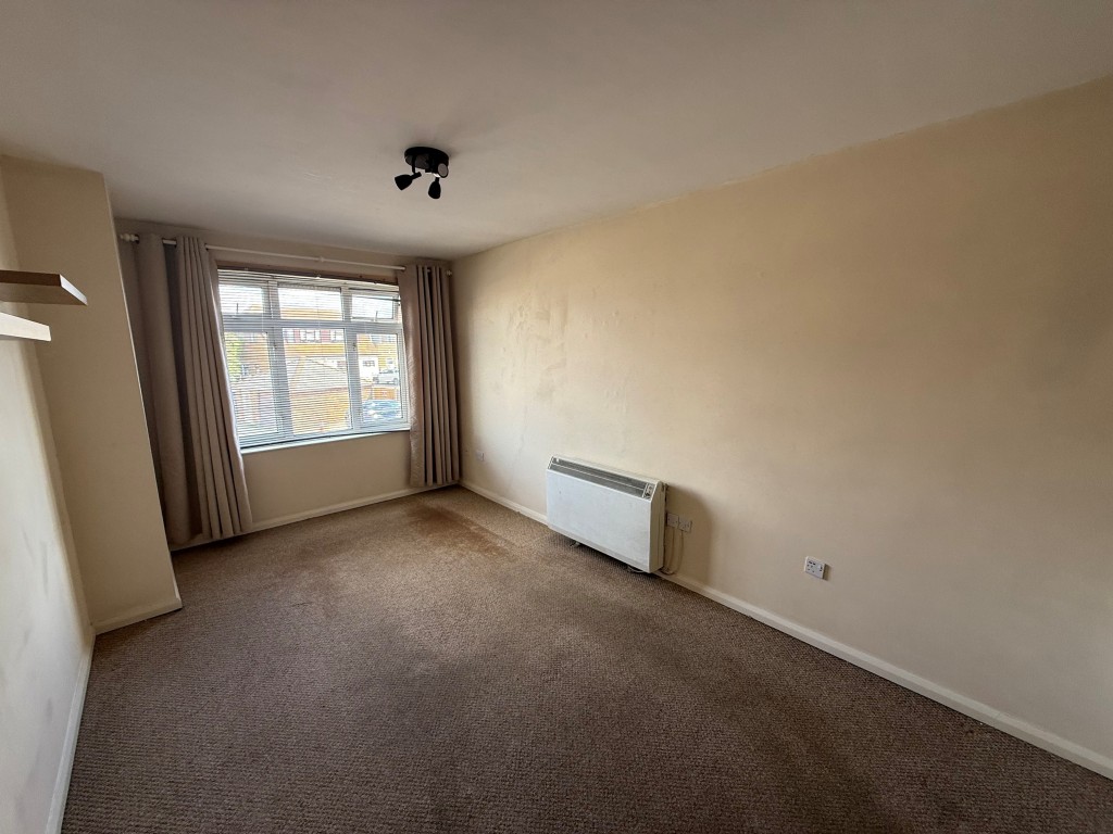 Lot: 219 - ONE-BEDROOM FLAT IN NEED OF MODERNISATION - Living room showing window and storage heater